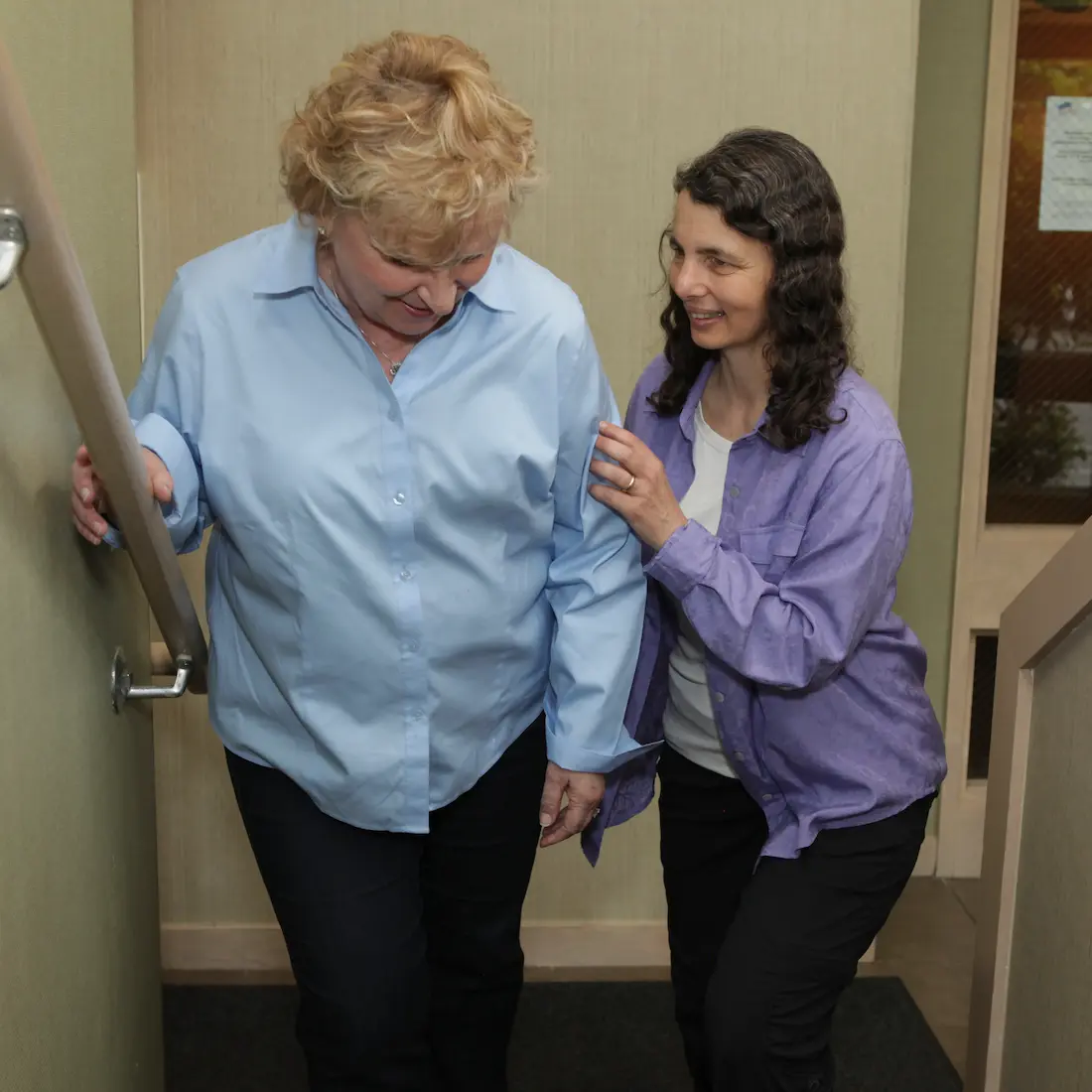 Laura Yedwab guiding a client up a flight of stairs